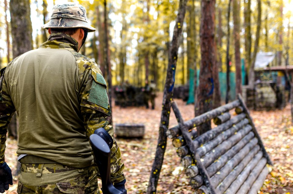 Selective Focus Photography Of Man Wearing Camoflouge Suit While Holding A Gun photo