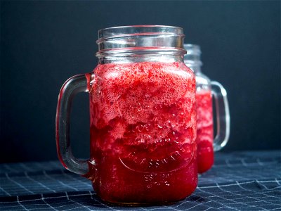 Closeup Photography Of Two Clear Glass Jar Filled With Red Liquid On Top Of Blue And White Tattersal Textile photo