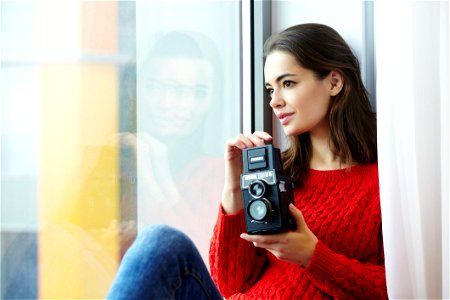 Woman Wearing Red Knitted Shirt Holding Instant Camera photo