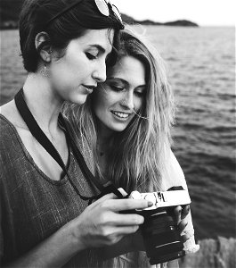 Grayscale Photo Of Two Women Looking At A Camera