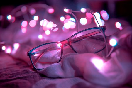 Shallow Focus Photography Of Blue-framed Eyeglasses Near String Lights