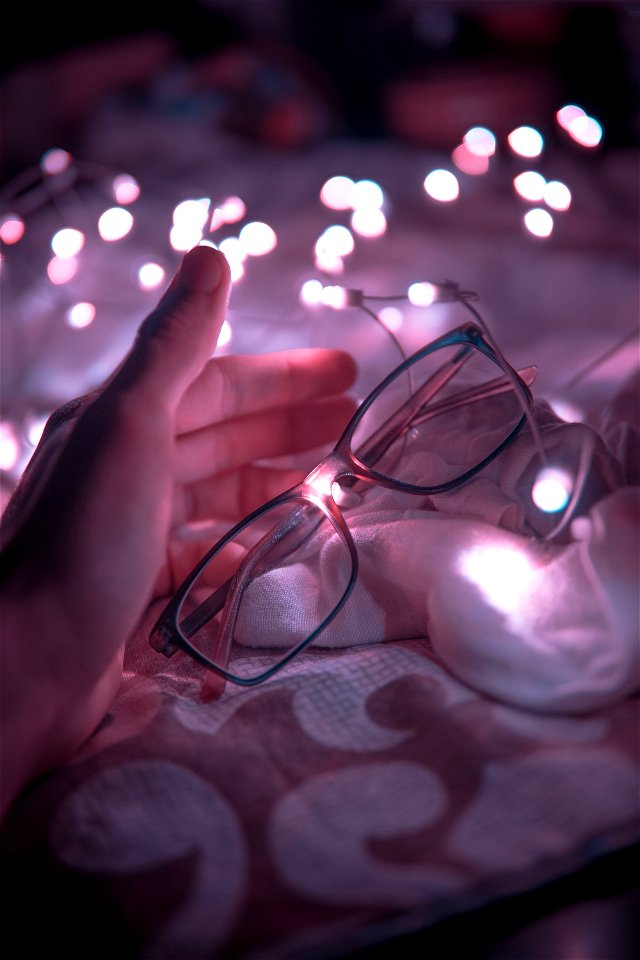 Black Frame Eyeglasses And White String Lights In White Textile photo