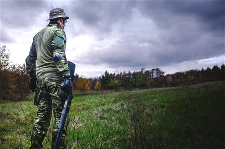 Man In Camouflage Soldier Suit While Holding Black Hunting Rifle photo