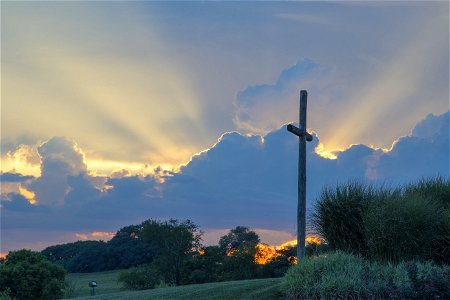 Big Wooden Cross On Green Grass Field Under The White Clouds photo