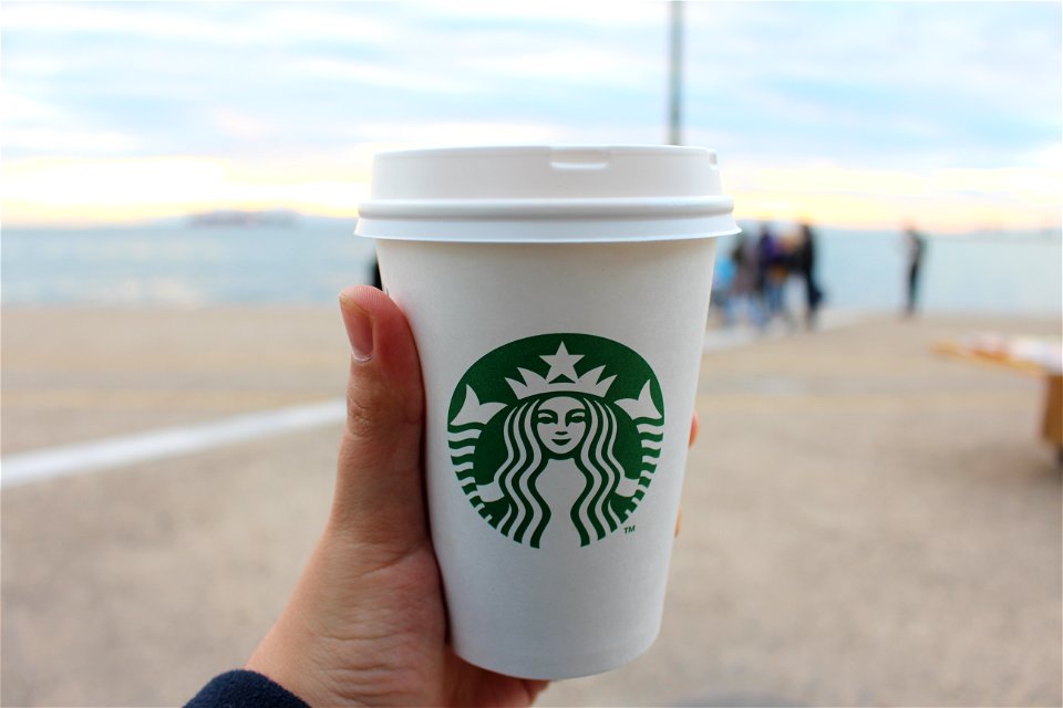 Person Holding Star Buck Plastic Cup photo