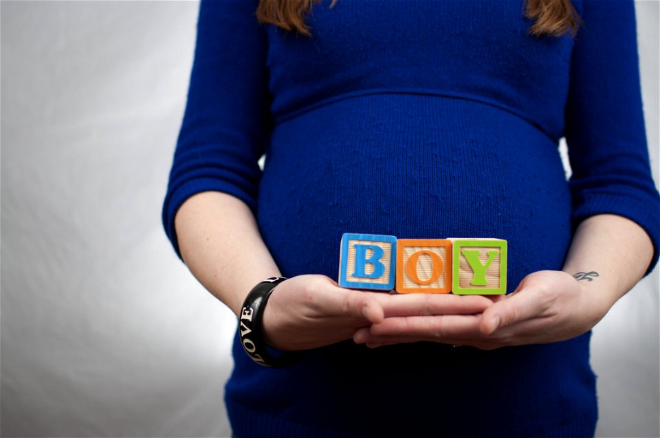 Lady Wearing Lbue Long Sleeve Dress And Holding Boy Piece Box photo