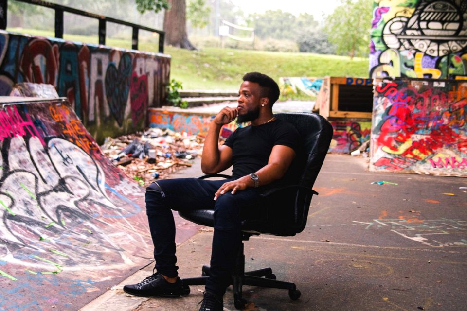 Man Wearing Black Crew-neck Shirt Sitting On Leather Rolling Chair