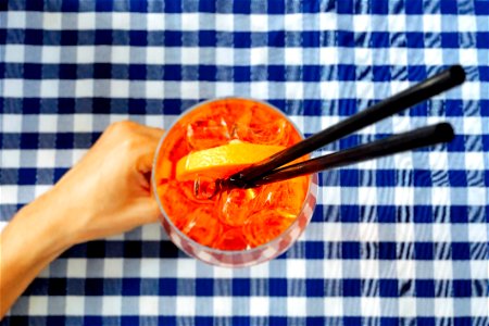 Person Holding Clear Drinking Glass With Two Black Straws photo