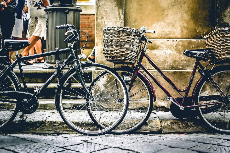 Two Black Bicycles Parting Near Wall