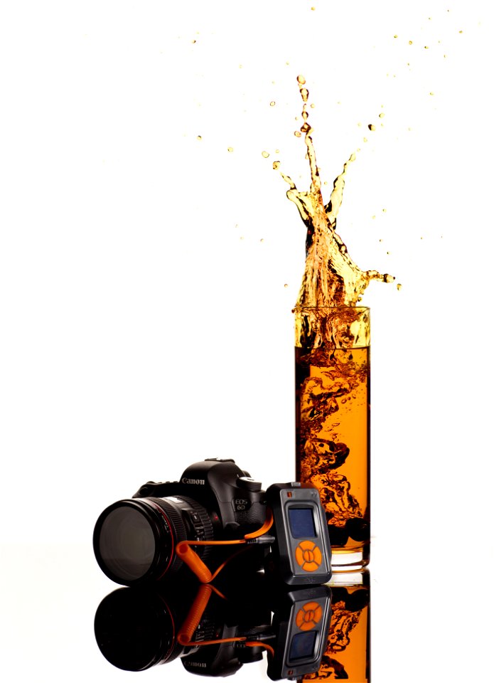 Black Canon Dslr Camera Behind Clear Highball Glass photo