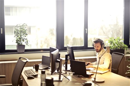 Man With Headphones Facing Computer Monitor photo
