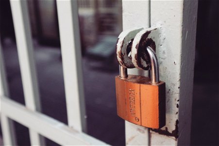 Closeup Photography Of White Gate With Brass-colored Padlock photo