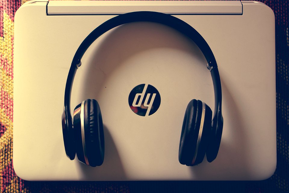 Black Wireless Headphone Near White Hp Laptop photo