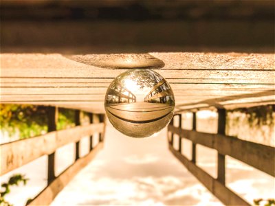 Macro Photography Of Round Glass Ball On Top Of Brown Wooden Dock photo
