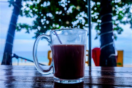 Clear Glass Mug With Beverage On Brown Wooden Table photo