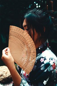 Japanese Woman Holding Brown Hand Fan photo