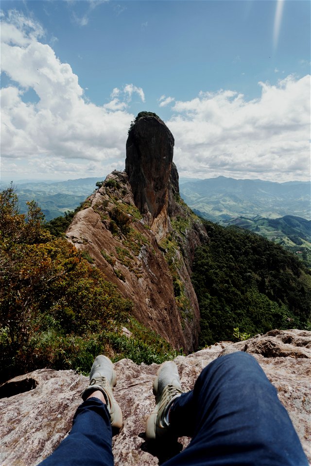 Person Sitting On Gray Rock Formation photo