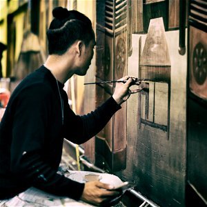 Man In Black Sweatshirt Holding Black Paint Brush Painting The Wall photo