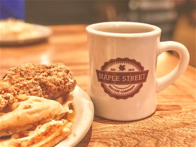 White And Brown Maple Street Ceramic Mug Beside Food photo