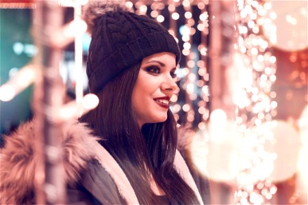 Selective Focus Photography Of Woman Wearing Black Cap And Gray Parka Jacket Surrounded By Lights photo