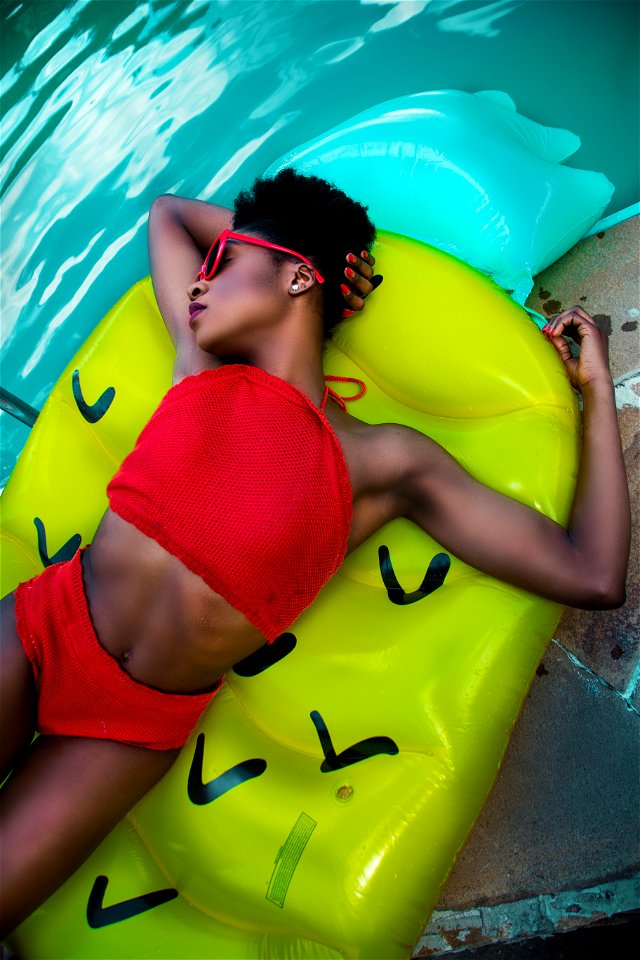 Woman Wearing Red Bikini Top With Pantie Laying On Inflatable Bed