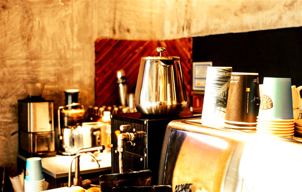 Stainless Steel Coffee Pot And Disposable Cups On Top Of Counter