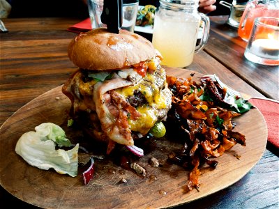 Loaded Burger On Wooden Plate photo