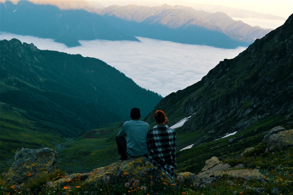 Two Person Sitting On Edge Of Mountain Photograph photo