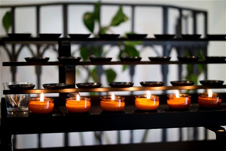 Close Up Photography Of Tealight Candles On Black Metal Rack photo