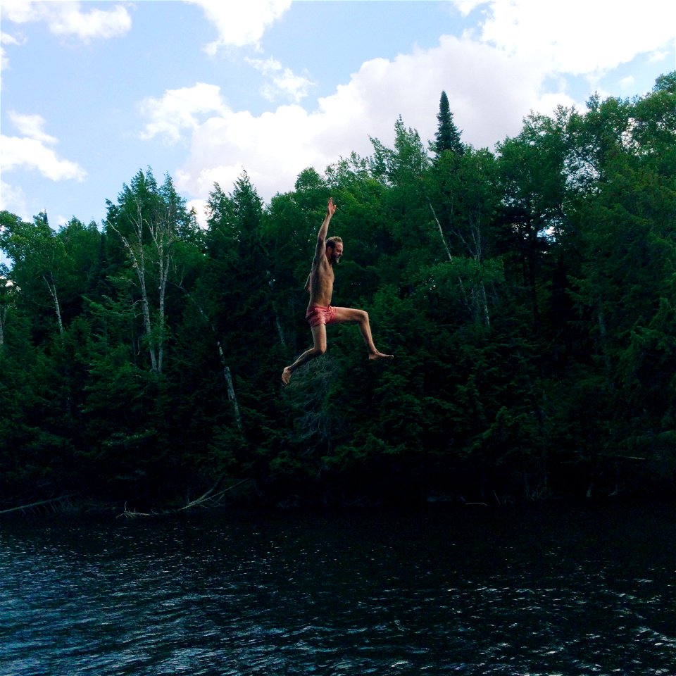 Man In Pink Shorts Jumping On Body Of Water photo