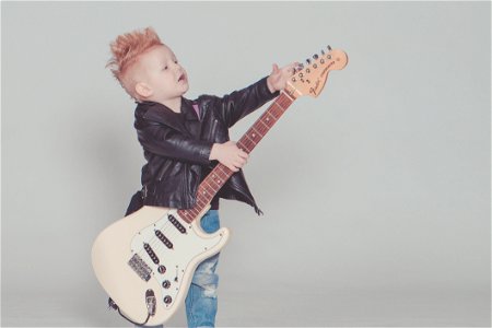 Boy Wearing Black Jacket Holding Electric Guitar photo