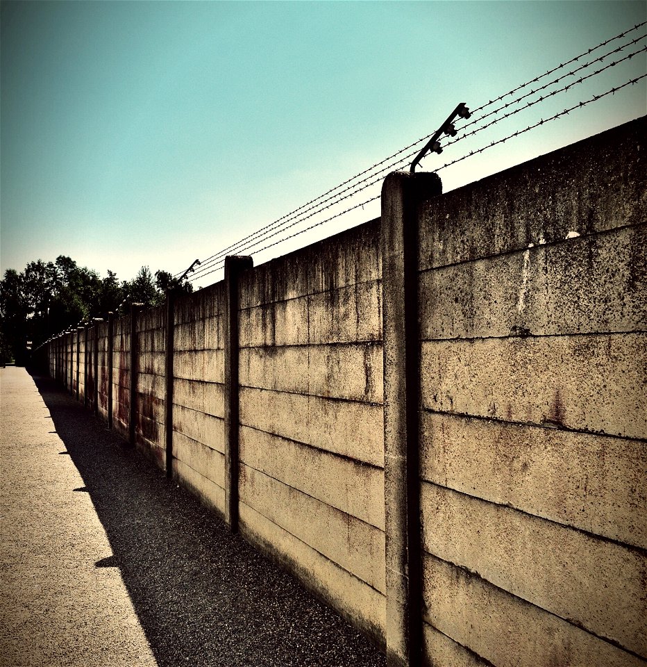Beige And Black Concrete Wall With Barbwire On Top photo