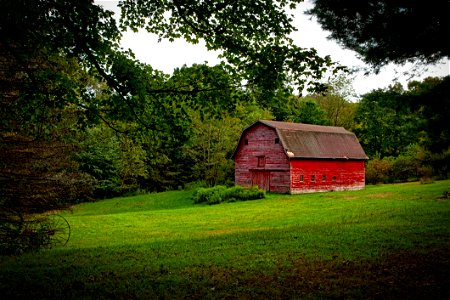 Barn In The Middle Of Lawn Surrounded With Trees During Daytime photo
