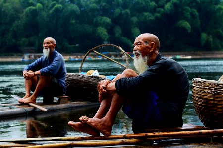 Two Men Sitting On Riverbank photo