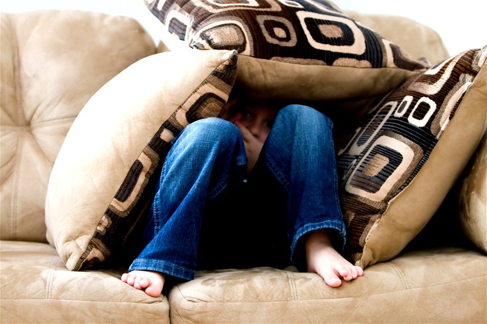 Boy Hiding In Couch Cushions photo