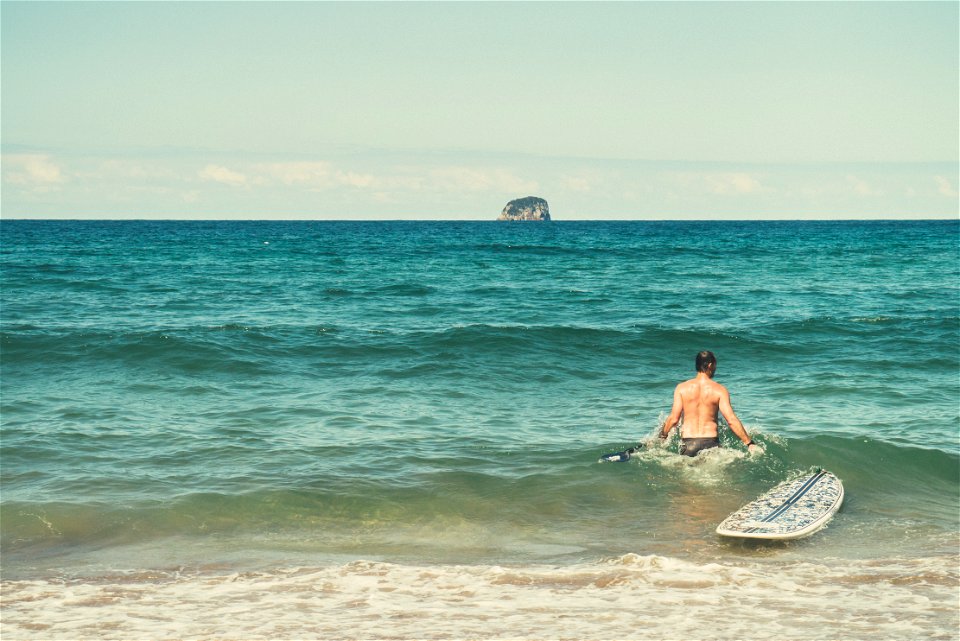 Male Surfer With Surfboard In Ocean photo