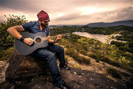Man Playing Guitar On Hilltop photo