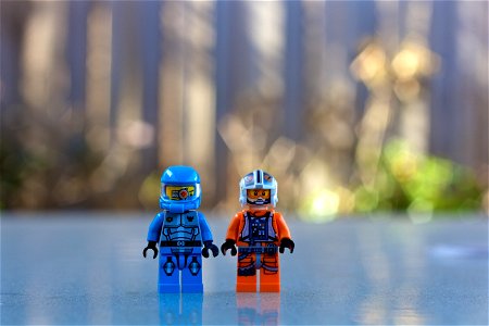 Blue Lego Toy Beside Orange And White Lego Toy Standing During Daytime photo