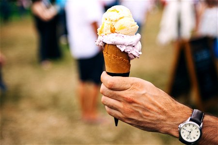 Person Holding Yellow And Purple Ice Cream photo