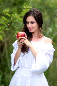 Woman Wearing White Off Shoulder Top Holding Red Apple Fruit photo