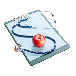 Stethoscope and apple on clipboard