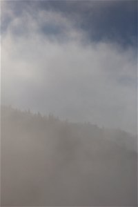 Mountainside Silhouette Through Thick Fog photo