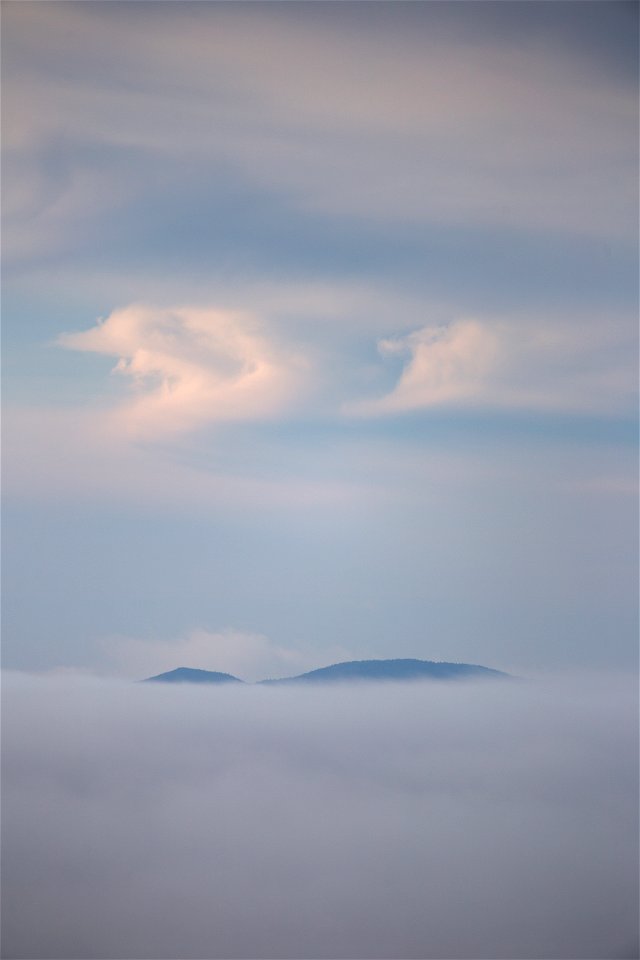 Mountaintop Peeking Over Thick Cloud Cover photo