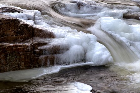 Water Flowing Through Frozen River photo