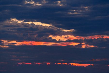 Peeks of Orange Sky Through Thick Clouds photo