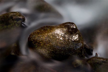 Swirling Water Around a Small Rock photo