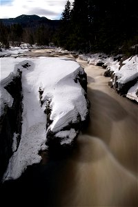 River Moving Through Snow-Covered Rocks photo