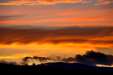 Fiery Clouds Over Mountain Silhouette photo