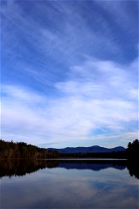 Wispy Clouds Reflected in Still Pond photo