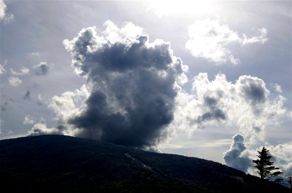 Sunlit Clouds Rolling Over Mountaintop
